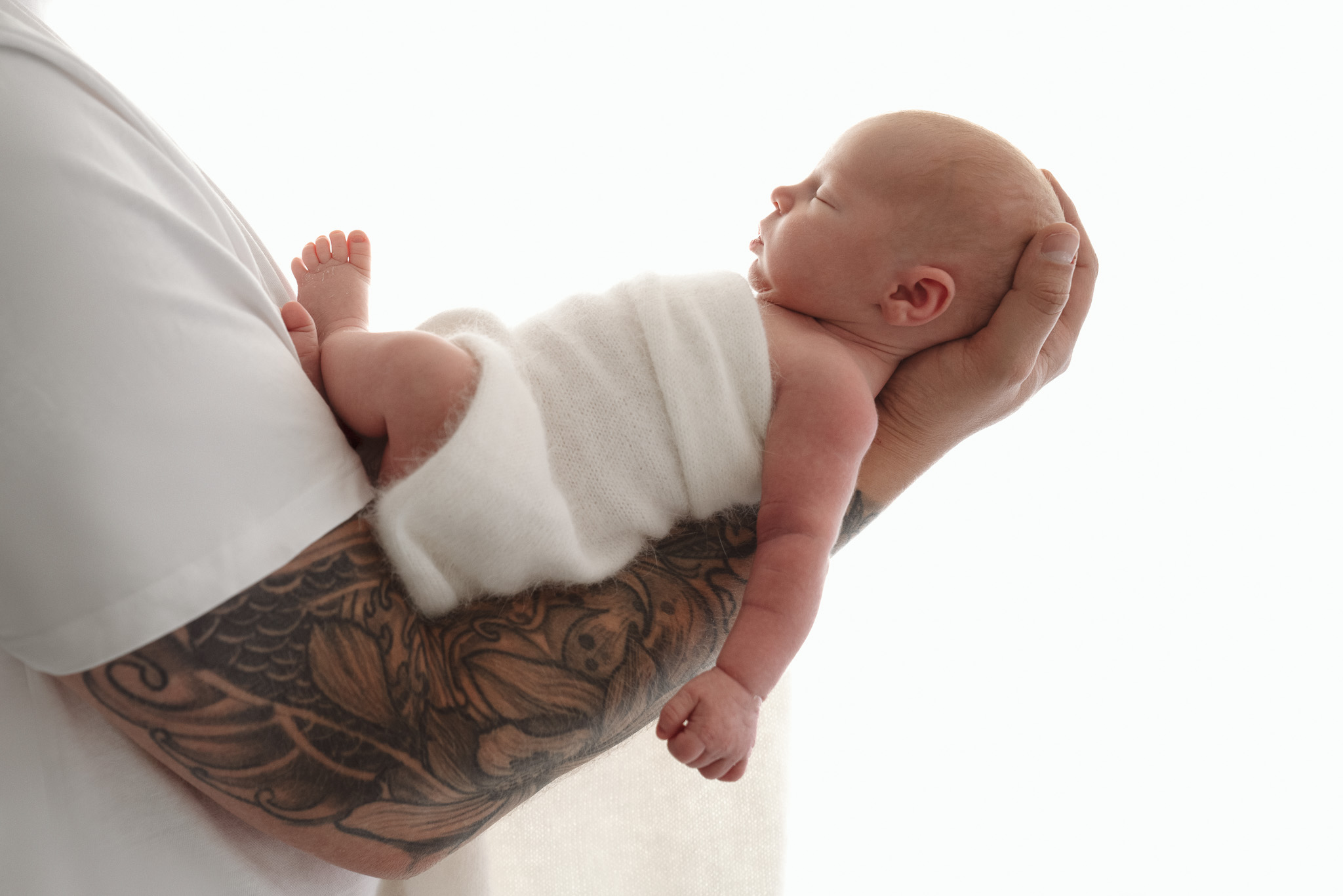 Pasgeboren baby in vaders handen