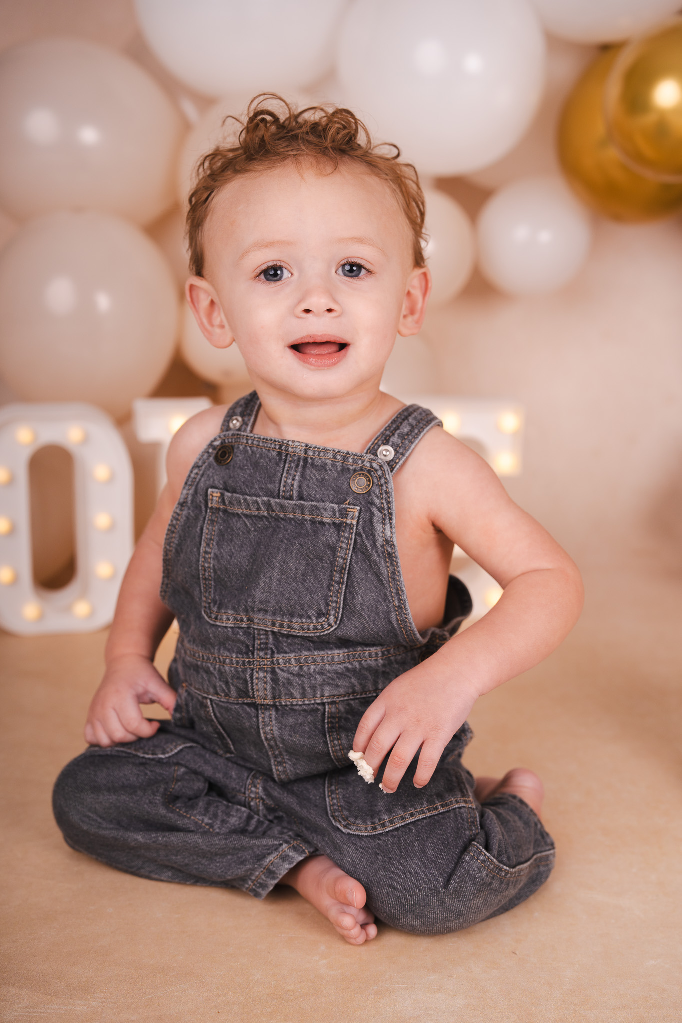 Baby in tuinbroek die zijn eerste verjaardag viert