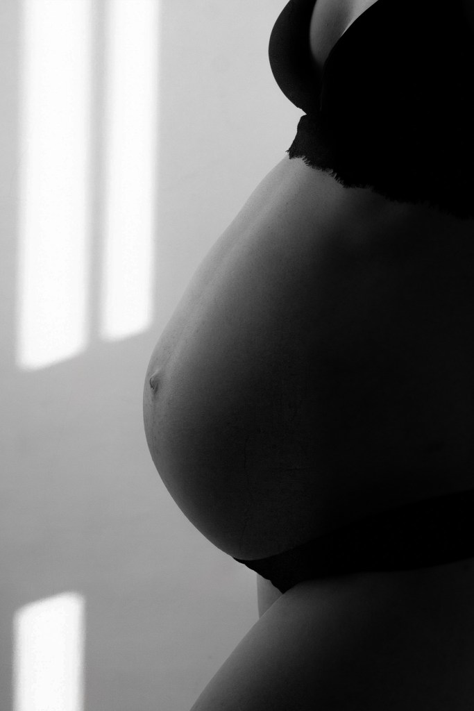 Detail van zwangere buik met speciaal licht in de studio Goes